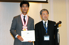 兼松会長（右）からメダルと賞状を受け取った斉田総会会長（左）